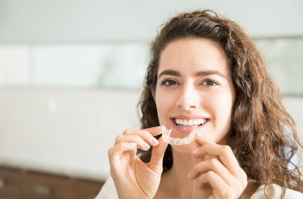 Woman Holding Invisalign Aligners