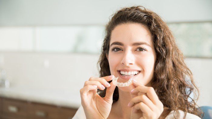 Woman Holding Invisalign Aligners